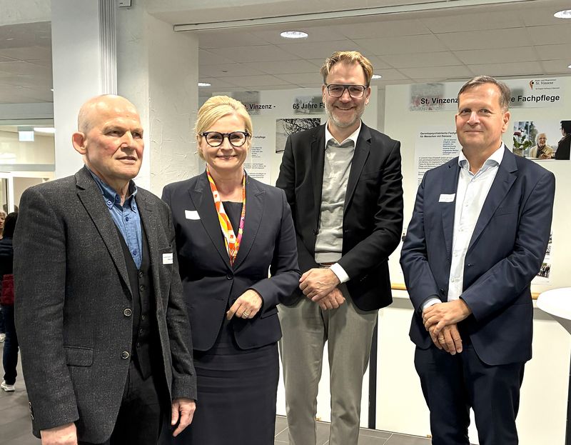 Vier Personen stehen in einer Gruppe zusammen