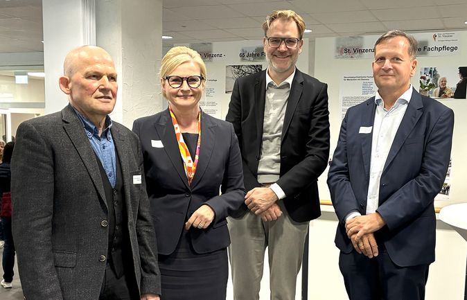 Vier Personen stehen in einer Gruppe zusammen