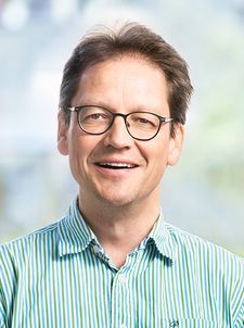 Lächelnder Mann mit Brille in grün gestreiftem Hemd