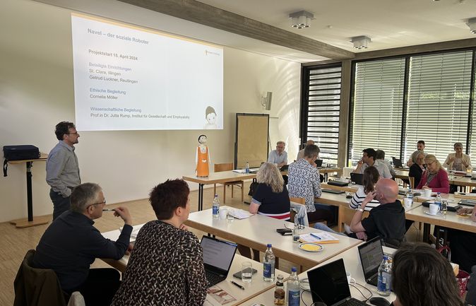 Leitungskonferenz der Keppler-Stiftung mit Vortrag und orangefarbenem Sozialroboter