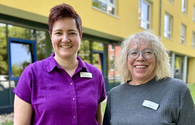 Zwei lächelnde Mitarbeiterinnen vor dem Haus Augustinus, links Einrichtungsleitung