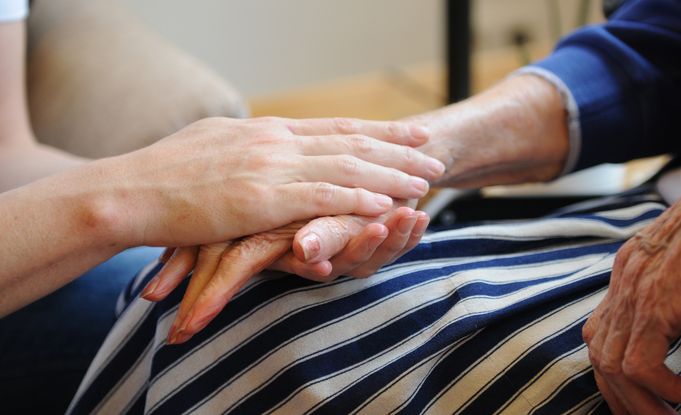 Jüngere Hand hält behutsam die Hand einer älteren Person