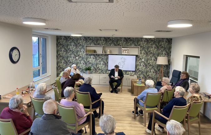 Lesung in Gemeinschaftsraum mit älteren Zuhörern