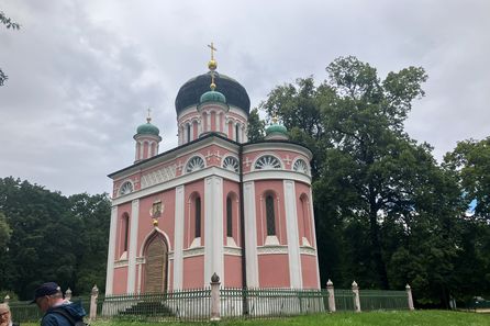 rosafarbene Kirche mit grünen Zwiebeltürmen und goldenen Kreuzen
